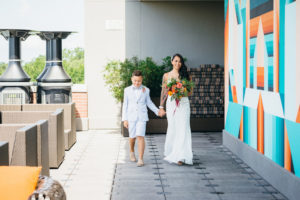 Wedding Ceremony Portrait, Bride with Orange and Red Floral Bouquet with Greenery, With Son in Light Blue Suit with Spotted Bow Tie | Downtown Tampa Rooftop Wedding Ceremony Venue The Epicurean