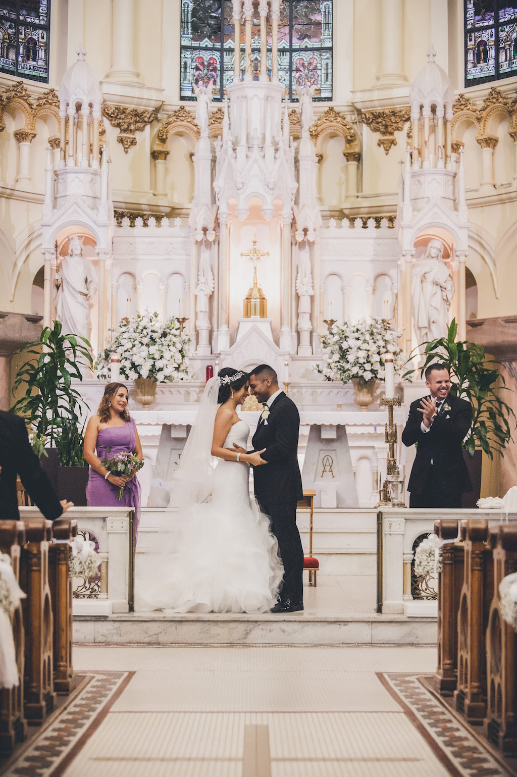 Traditional Church Wedding Ceremony, With White and Greenery Flower Arrangements, Bridesmaid in Strapless Purple Vera Wang Dress, Bride in Pronovias Layered Mermaid Strapless Dress | Downtown Tampa Venue Sacred Heart Catholic Church