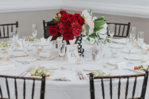 Modern, Red and White Wedding Reception Round Table Decor with Red ROse and WHite Floral with Greenery Low Centerpiece in Wrought Iron Vase, with Elegant Printed Table Number and Wood Chiavari Chairs | Tampa Bay Wedding Planner Special Moments Event Planning