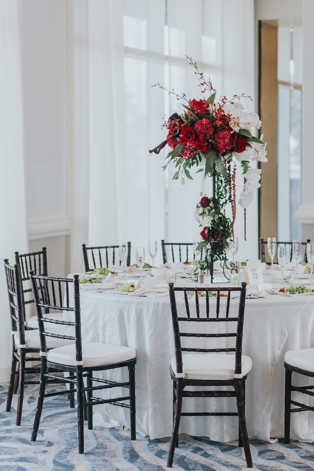 Modern, Red and White Hotel Ballroom Wedding Reception with Extra Tall Red and White Floral with Greenery Centerpiece and Brown Wood Chiavari Chairs | Hotel Wedding Venue Hyatt Regency Clearwater Beach | Tampa Bay Wedding Planner Special Moments Event Planning