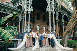 Downtown Tampa Outdoor Wedding Party Portrait with Historic Architecture, Bridesmaids in Taupe Floorlength Azazie Dresses, Groom in Blue Suit, Groomsmen in White Shirts with Taupe Ties