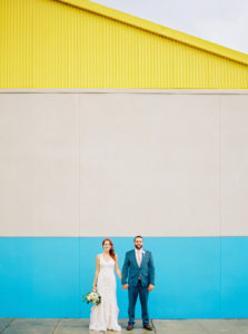Downtown Tampa Creative Wedding Portrait, Bride in Sweetheart Lace Stella York Dress with White and Greenery Bouquet, Groom in Blue Suit | Wedding Planner Glitz Events