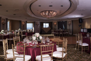Gold and Burgundy Hotel Ballroom Wedding Reception with Red Linens, Gold Chargers and Chiavari Chairs, and Low White Hydrangea and Blush Pink Rose with Greenery Centerpieces | Downtown Tampa Wedding Venue The Tampa Club