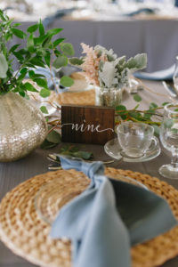 Outdoor Tented Wedding Reception with Organic Greenery Inspired Decor, Long Feasting Tables, Wicker Placemat Chargers, Wooden Table Numbers and Candle Centerpieces | Sarasota Wedding Planner Jennifer Matteo Event Planning