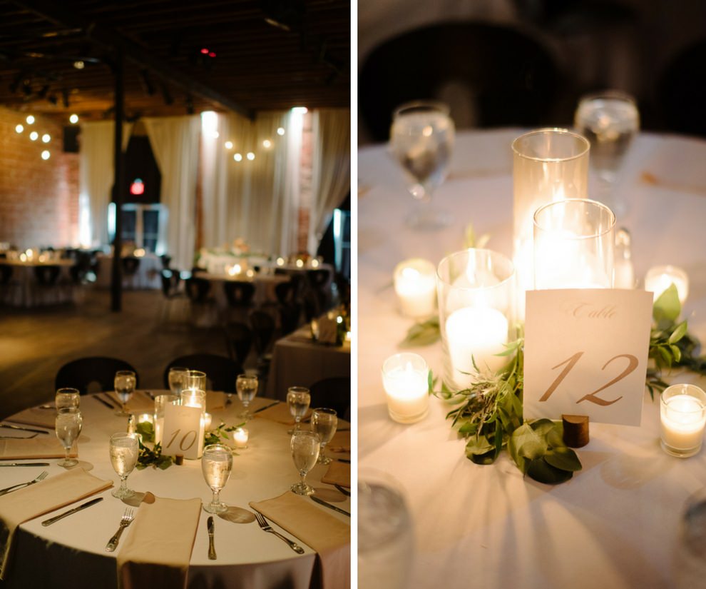 Candlelit Wedding Reception with Champagne and White Linens, Pillar Candles in Glass Holders with Greenery Centerpiece and Gold Printed Paper Table Number Card, Hanging Edison Bulb String Lights | Downtown St Pete Unique Wedding Venue NOVA 535