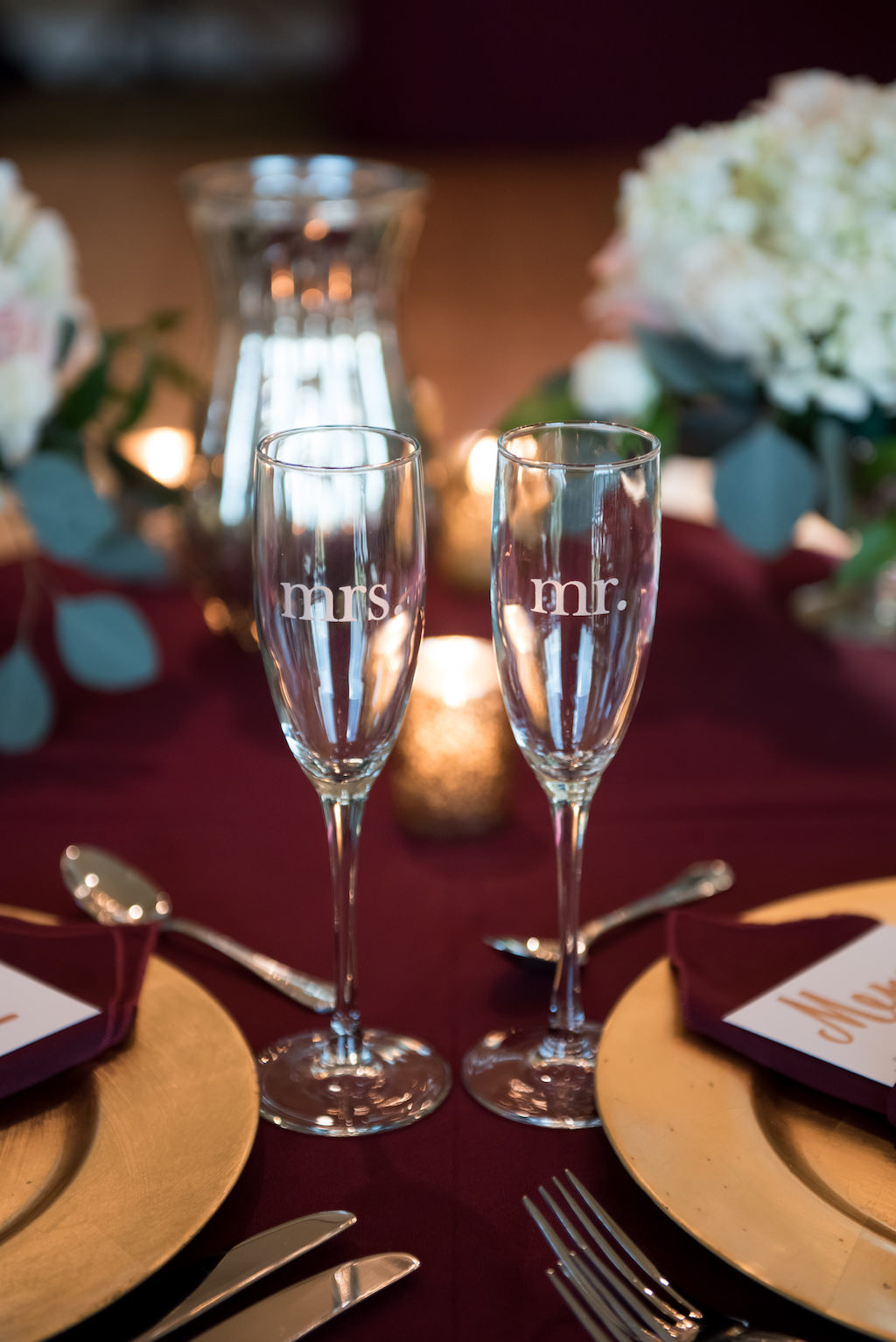 Burgundy and Gold Wedding Reception Sweetheart Table with Mr and Mrs Champagne Flutes, with Red Linens
