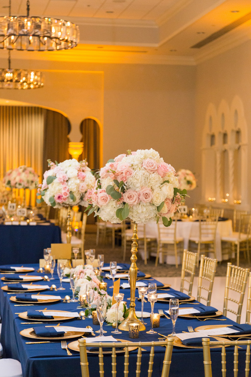 Southern Charm Hotel Ballroom Wedding Reception with Tall White and Pink with Greenery Centerpiece in Gold Candelabra Vase, with Gold Chiavari Chairs and Chargers, Navy Blue Linens and Tablecloth | St Pete Historic Hotel Wedding Reception Venue The Vinoy Renaissance