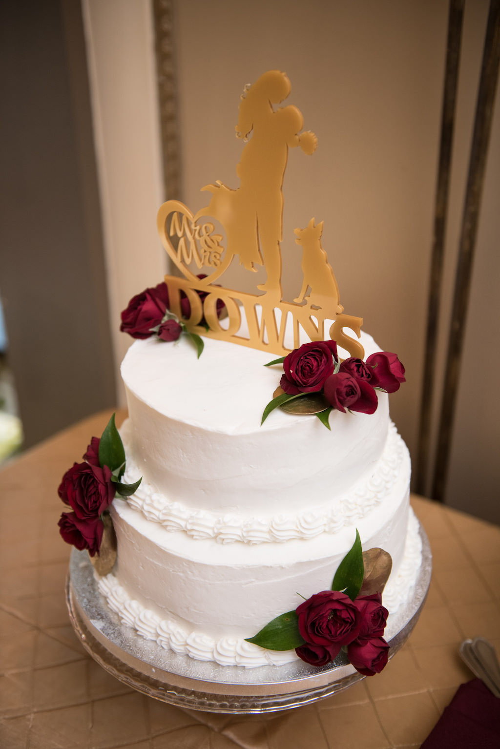 Gold and Burgundy Wedding Two tier round white Wedding Cake with Custom Silhouette Bride and Groom and Dog Cake Topper with Red Roses on Silver Cake Stand