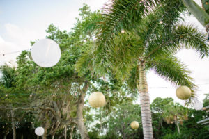 Outdoor Beach Wedding Reception Palm Trees Wrapped in String Lights with White and Gold Chinese Paper Lanterns | Sarasota Wedding Planner NK Productions