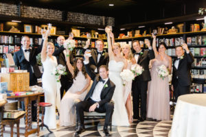 Indoor Wedding Party Portrait in Vintage Bookstore, Bridesmaids in Mismatched Blush Dresses with White Floral and Greenery Bouquets , Groomsmen in Classic Black Tuxedos | Tampa Bay Wedding Photographer Ailyn La Torre Photography | Venue The Oxford Exchange
