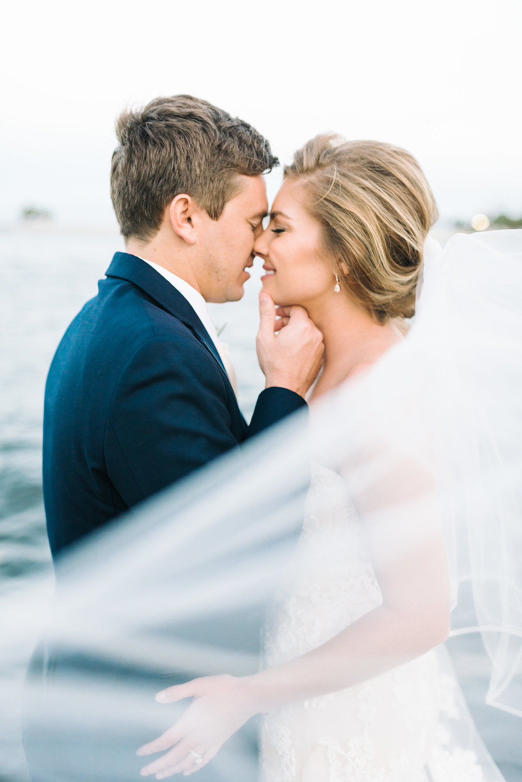 Outdoor Downtown St. Pete Waterfront Wedding Portrait, Bride wearing Lace Sweetheart Strapless Enzoani Wedding Dress, Groom in Blue Suit