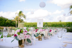 Outdoor Garden Tropical Wedding Reception with Small Pink Rose, White and Magenta Floral with Greenery Centerpieces in Small Gold Mercury Vases, Pillar Candles in Glass with Sand, Shells, and Starfish, Gold Geometric Printed Table Number, and String Lights with Round Paper Lanterns | Tampa Bay Wedding Planner NK Productions | Sarasota Beach Wedding Venue Longboat Key Club