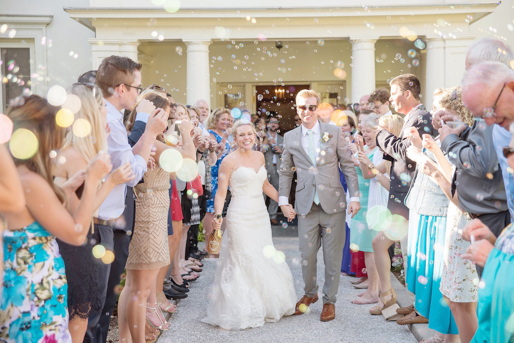 Outdoor Wedding Exit Portrait with Bubbles, Groom in Gray Suit with Brown Shoes and Mint Green Tie, Bride in Strapless Mermaid Lace Allure Bridals Dress | Sarasota Wedding Photographer Kristen Marie Photography