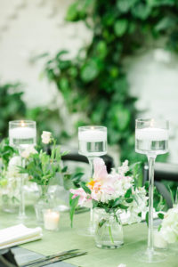 Indoor Ivory Garden Wedding Reception Industrial Metal Feasting Table with Low Pink and White Floral with Greenery Centerpieces in Glass Jars, and Floating Votive Candles in Tall Glass Holders | Downtown Tampa Wedding Venue The Oxford Exchange