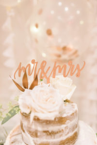 Copper Mr and Mrs Wedding Cake Topper with Naked Frosting Round Cake and White Flowers and Balloons