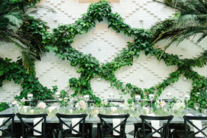 Indoor Ivory Garden Wedding Reception Industrial Metal Feasting Table with Low Pink and White Floral with Greenery Centerpieces, Black Crossback Chairs, and Floating Votive Candles in Tall Glass Holders | Downtown Tampa Wedding Venue The Oxford Exchange