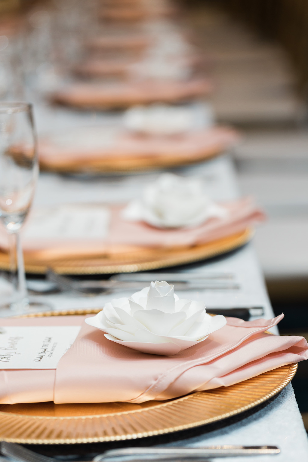 Whimsical Wedding Reception Table Setting with Gold Charger and White Paper Flower, Pink Napkin, and Tropical Gold Foil Printed Menu with Pink Sequin Linen
