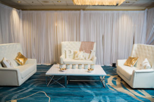 Pink and Gold Whimsical Wedding Reception with Stylish Highbacked White Lounge Loveseats, Gold Sequin Throw pillows, Rustic Glam Coffee Can Lanterns and Large Couple Initials | Tampa Bay Wedding Furniture Rentals and Draping Gabro Event Services | Hotel Ballroom Wedding Venue Hilton Clearwater Beach