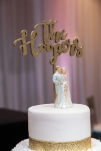 Four Tier Round White with Gold Glitter and Rose Icing Wedding Cake with Custom Figurine Cake Topper and Gold Couple Name