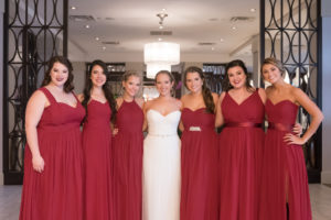 Hotel Interior Bridal Party Portrait, Bride in Strapless Belted Maggie Sottero Wedding Dress, Bridesmaids in Mismatched Burgundy Red Azazie Dresses | Tampa Wedding Photographer Carrie Wildes Photography