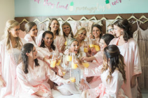 Indoor Bridal Party Getting Ready Portrait with Mimosas in Matching Pink Robes