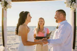 Outdoor Beach Wedding Ceremony with White Draped Wooden Ceremony Arch with Flowers and Greenery | Tampa Bay Officiant and Planner Gulf Beach Weddings