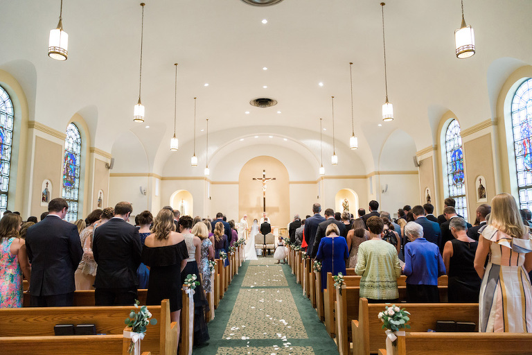 Traditional Church Wedding Ceremony Portrait, with White Floral and Greenery with Ribbon Flowers on Wooden Pews | St Pete Ceremony Venue St Paul's Catholic Church