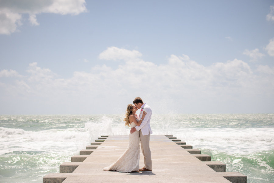Outdoor Beach Bride and Groom Portrait, Bride in Strapless Lace Essense of Australia Wedding Dress, Groom in White Suit Jacket with Tan Pants | Sarasota Longboat Key Wedding Planner NK Productions