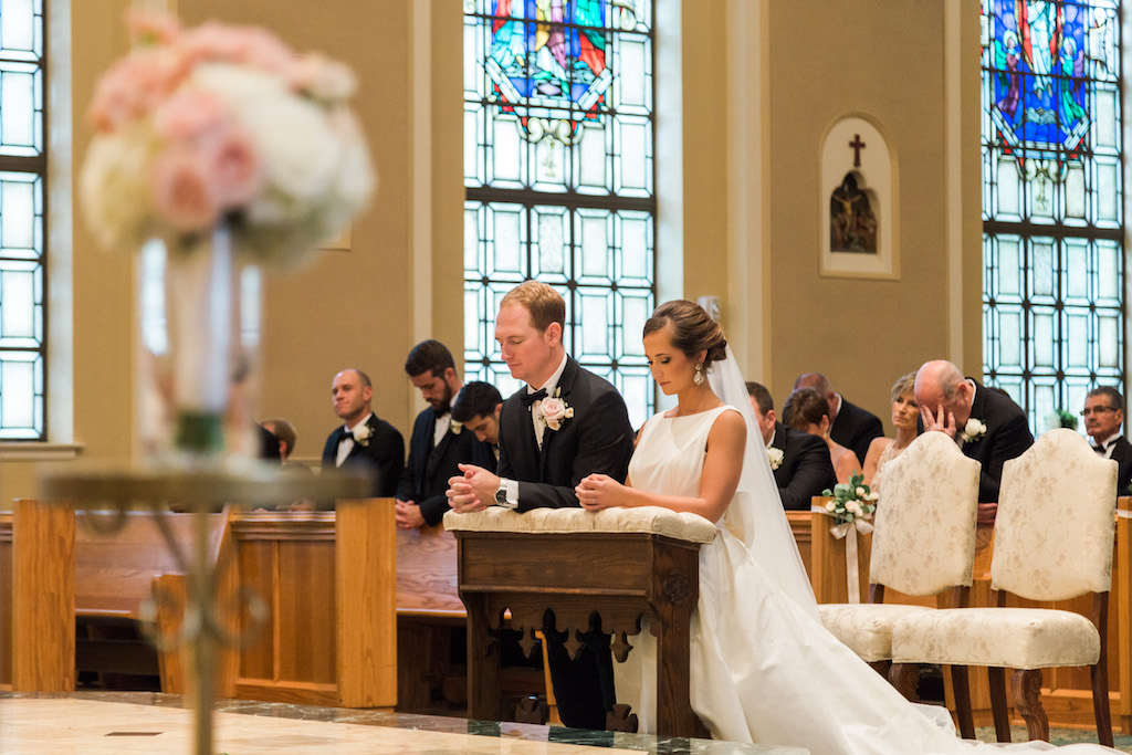 Traditional Church Wedding Ceremony Portrait, with White Floral and Greenery with Ribbon Flowers on Wooden Pews | St Pete Ceremony Venue St Paul's Catholic Church