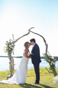 Outdoor Waterfront Wedding Ceremony Portrait with Organic Driftwood Arch with White Rose and Natural Greenery Florals, Bride in Lace Open Back Column Dress with Train | Venue Tampa Bay Watch | St Petersburg Wedding Photographer Lifelong Photography Studio