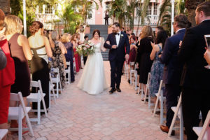 Outdoor Hotel Courtyard Wedding Ceremony with Blush Pink, White and Burgundy Bouquet with Greenery | Historic Waterfront Hotel St Pete Beach Wedding Venue The Don CeSar | Photographer Marc Edwards Photographs