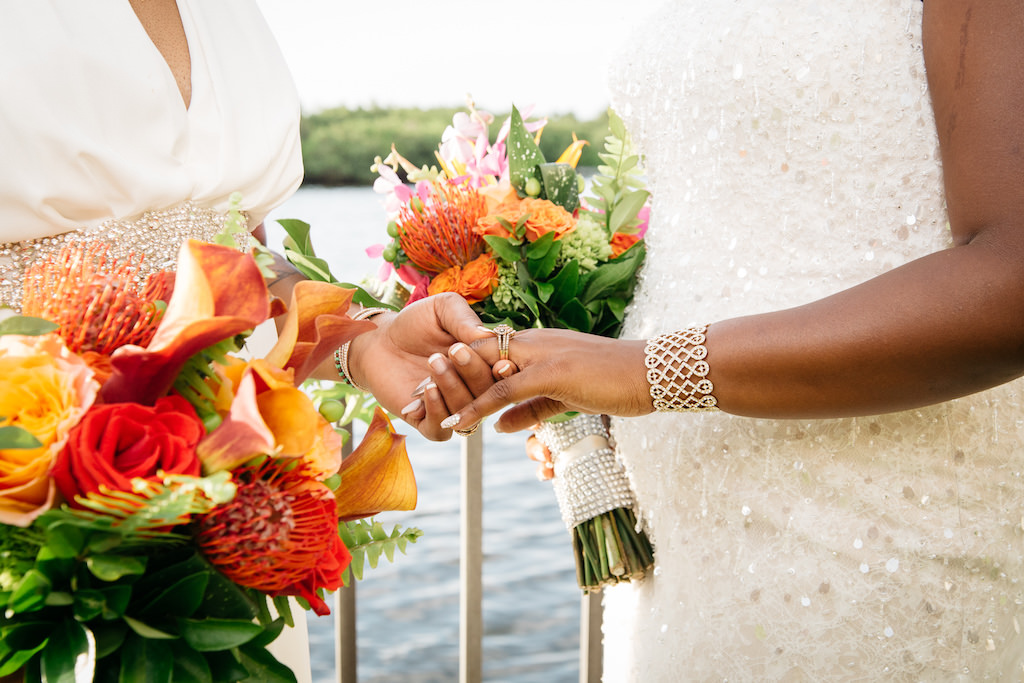 Outdoor Waterfront Bridal Same Sex Wedding Portrait, with Orange Lilly, Guava and Red Rose, with Purple Floral and Tropical Greenery Bouquet