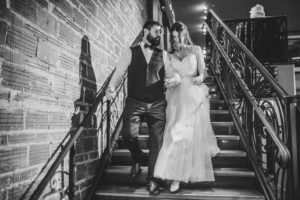 Indoor Bride and Groom Wedding Portrait on Vintage Stair Case with Exposed Brick, Bride in Long Sleeve Belted Davids Bridal Ballgown Dress | Historic Downtown St Pete Venue NOVA 535