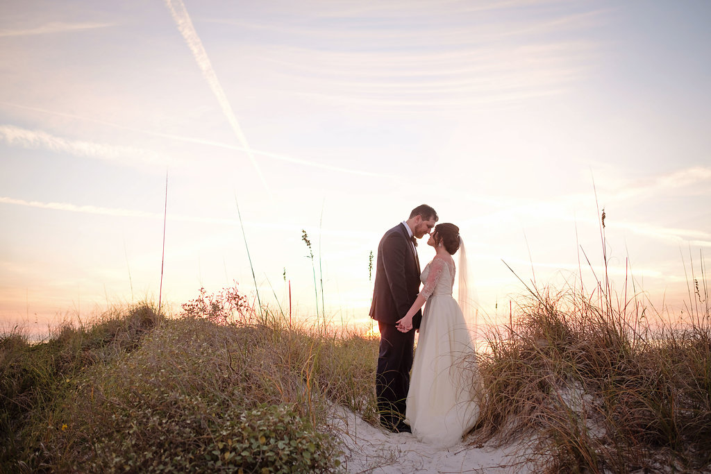 Outdoor Beach Sunset Bride and Groom Wedding Portrait, Bride in Lace Sleeve Silver Belted A Line Wedding Dress | St Pete Beach Wedding Venue The Don CeSar | Tampa Bay Photographer Marc Edwards | Bridal Hair and Makeup Femme Akoi Studio