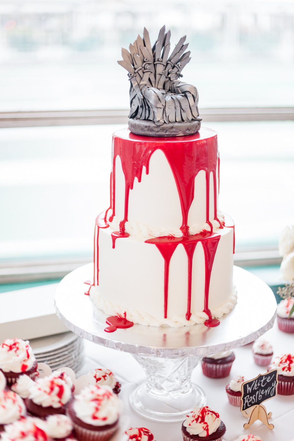 Two Tiered Round White Wedding Cake with Dripping Red Icing, and Custom Game of Thrones Silver Cake Topper with Red Velvet Cupcakes