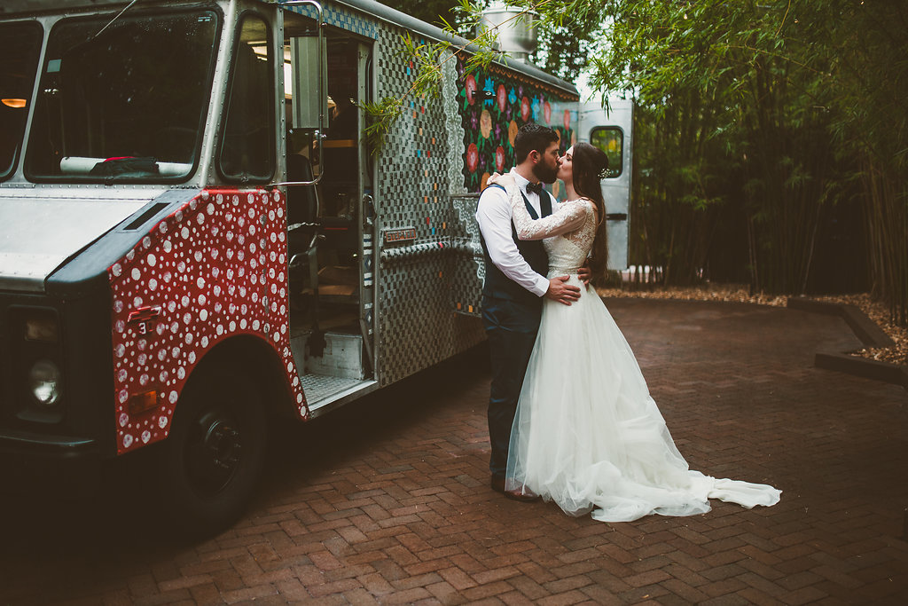 Outdoor Wedding Reception Portrait In Bamboo Courtyard Garden with Food Truck, Groom in Navy Blue Vest and Bow Tie, Bride in Lace Long Sleeve Ballgown Davids Bridal Dress | Unique Downtown St Pete Wedding Venue NOVA 535