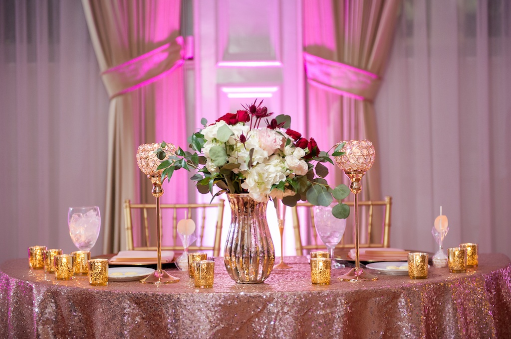 Country Club Ballroom Wedding Reception Sweetheart Table with Tall White Hydrangea, Red Rose and Burgundy Thistle with Greenery Centerpiece in Gold Vase, with Gold MErcury Votive Candles and Tall Gold Lanterns, with Sequin Linen and Gold Chiavari Chairs