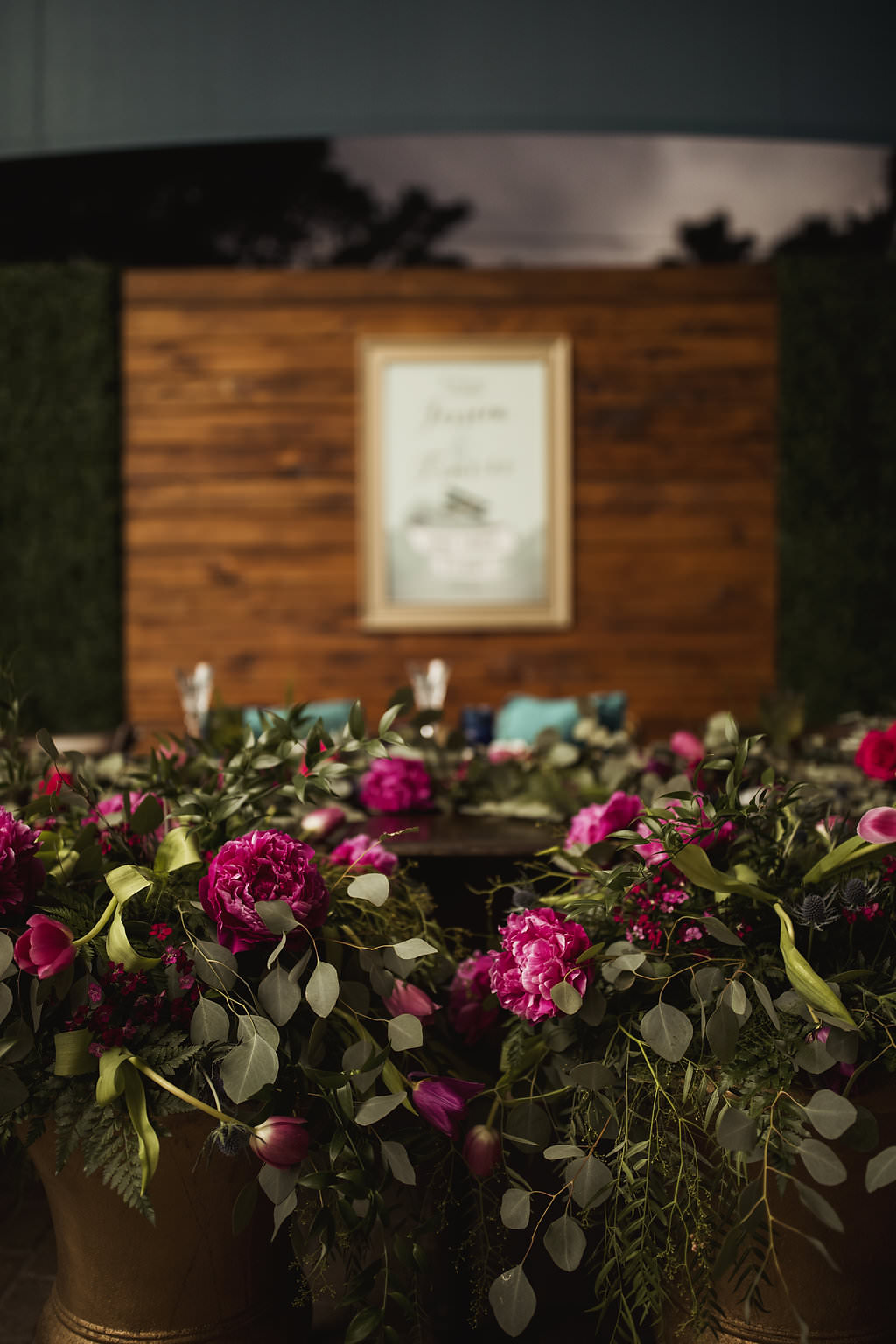 Jewel Toned Wedding Reception Pink and Tropical Florals in Gold Planters, Gold Framed Welcome Sign on Wooden Backdrop | Sarasota Planner Jennifer Matteo Event Planning