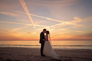 Outdoor Beach Sunset Bride and Groom Wedding Portrait, Bride in Lace Sleeve Silver Belted A Line Wedding Dress | St Pete Beach Wedding Venue The Don CeSar | Tampa Bay Photographer Marc Edwards | Bridal Hair and Makeup Femme Akoi Studio