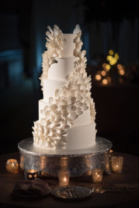 Five Tier Round White Wedding Cake with Feather Wing or Flower Petal Decorations on Silver Cake Stand with Votive Candles
