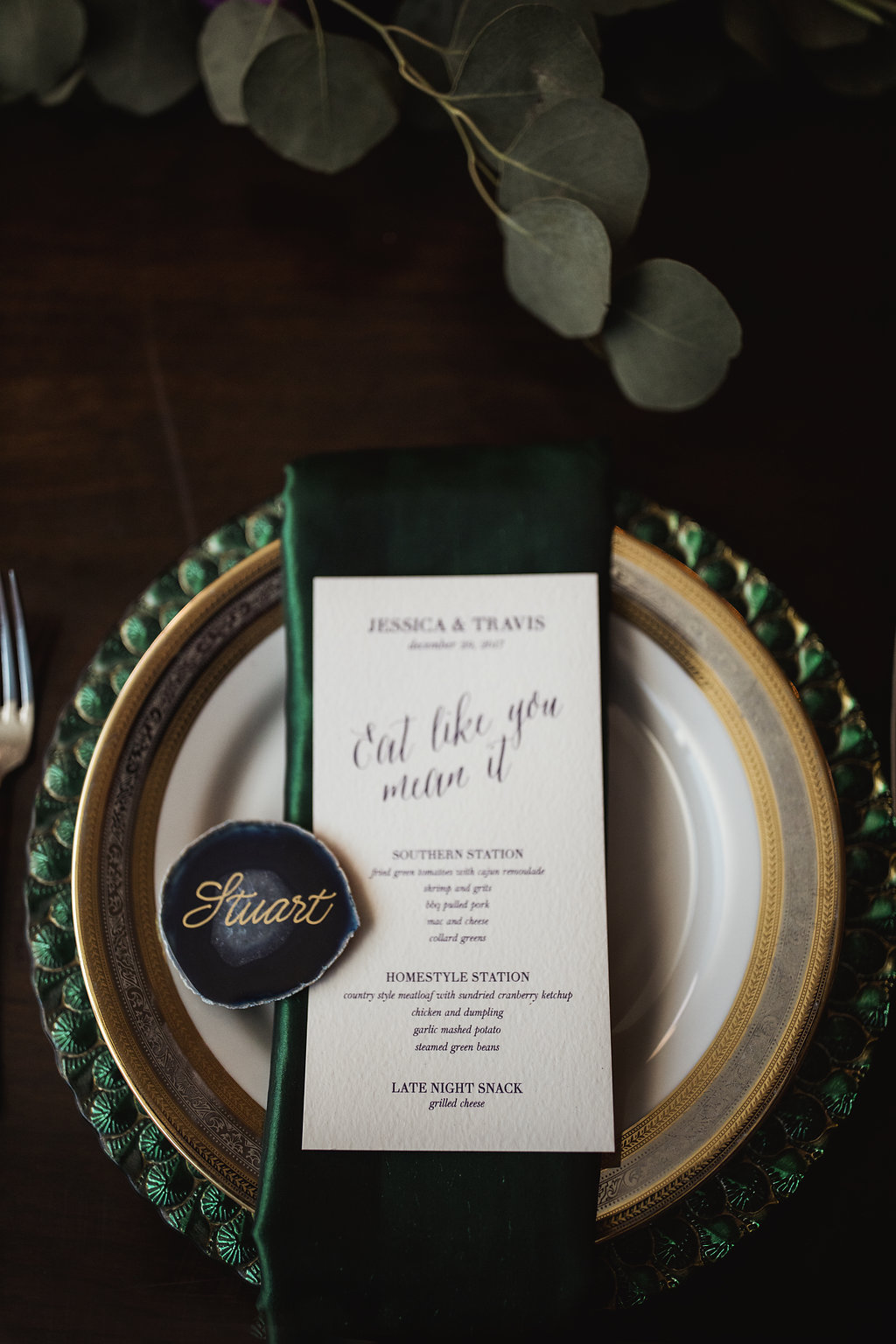 Jewel Tone Wedding Reception with Green Satin Napkin and Gold Charger, Gold Script on Blue Geode Place Card, and Greenery Garland Centerpiece on Wooden Table | Tampa Bay Wedding Planner Jennifer Matteo Event Planning