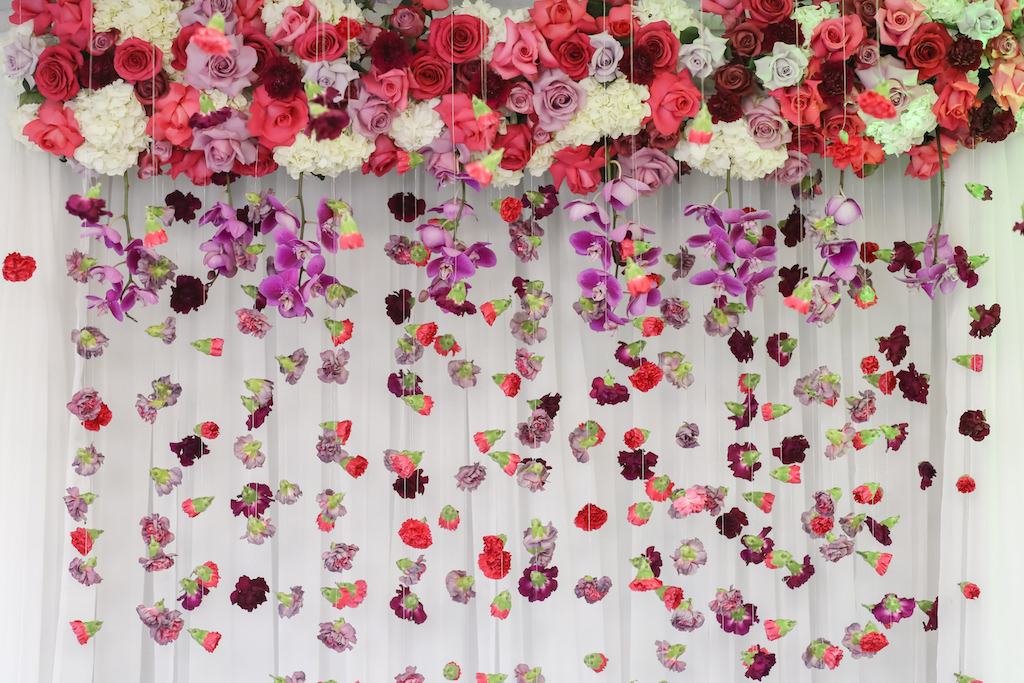 White Hydrangea with Purple Orchid, Pink and Red Rose Arch with Hanging Carnation Flowers and White Draping | Tampa Bay Wedding Florist Gabro Event Services