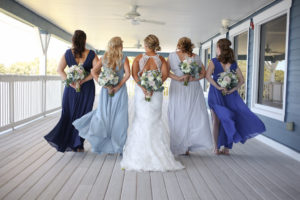Outdoor Porch Bridal Party Portrait, Bride in Lace Open Back Mermaid Wedding Dress, Bridesmaids in Match V Back Shades of Blue Lulus Dresses, With BLush, White, and Greenery Bouquets | St Pete Wedding Photographer Life Long Studios Photography | Venue Tampa Bay Watch