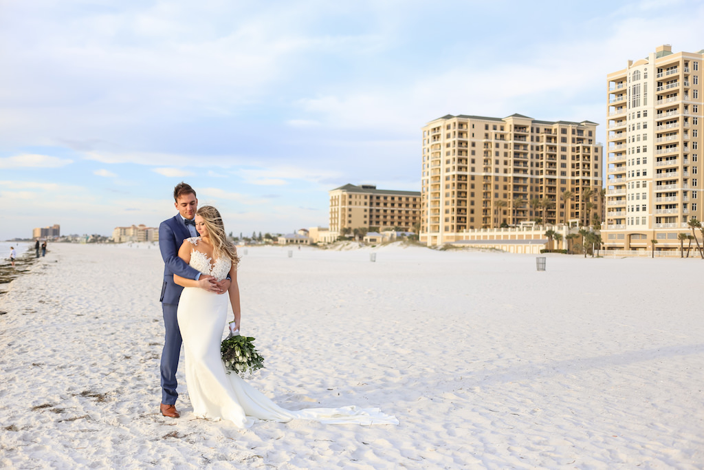 Outdoor Beach Wedding Portrait, Bride in Applique Lace Bodice Wedding Dress with White Floral, Blue Berry and Greenery Bouquet, Groom in Blue Suit with Blue Bow Tie | Tampa Bay Wedding Photographer Lifelong Photography Studio | Hotel Venue Hilton Clearwater Beach