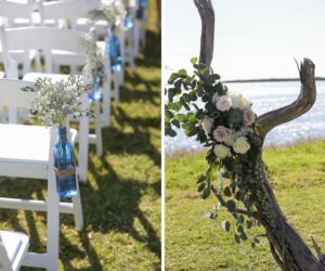 Outdoor Waterfront Wedding Ceremony Decor Details with Organic Driftwood with Blush Pink and White Roses with Natural Greenery, Folding Chairs with Blue Glass Bottles Tied with Twine and White Florals
