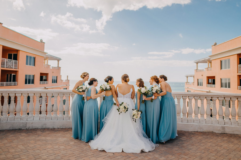 Outdoor Rooftop Bridal Party Portrait, Bridesmaids in Mismatched Light Blue Weddington Way Dresses, Bride in Spaghetti Strap Open Back Layered Ballgown Hayley Paige Wedding Dress, with Ivory Floral with Greenery Bouquets | Tampa Bay Wedding Photographer Rad Red Creative | Waterfront Luxury Hotel Venue Hyatt Regency Clearwater Beach