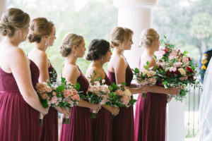 Outdoor Wedding Ceremony Bridesmaids Portrait in Wine Red One Shoulder Long Dresses with BLush PInk, Ivory Rose with Greenery Bouquet