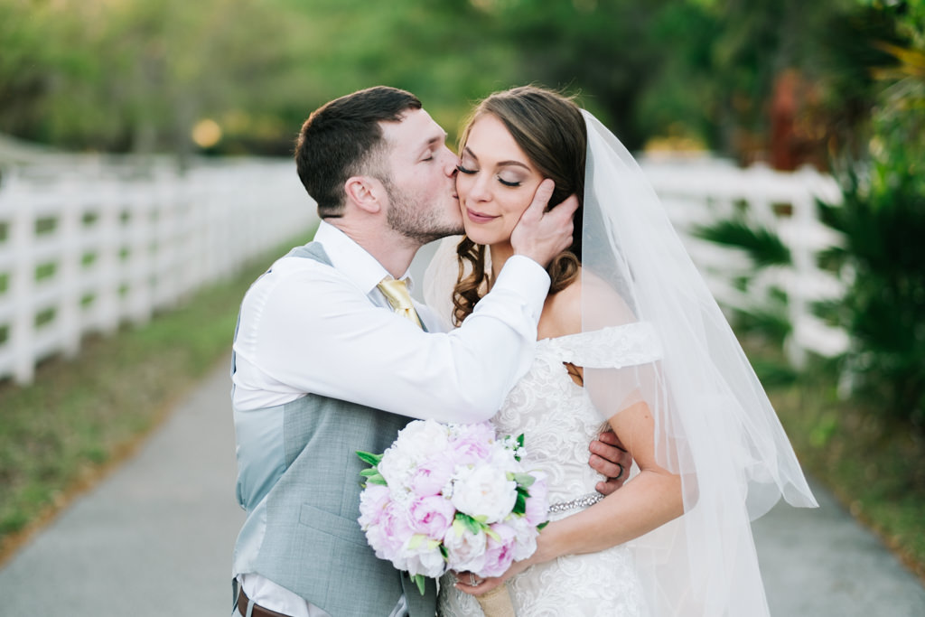 Outdoor Farm Wedding Portrait, Groom in Gray Suit Jacket and Gold Tie, Bride in Stella York Silver Belted Lace Dress, with White and Pink Peony with Greenery Bouquet | Tampa Bay Country Wedding Venue Southern Plantation Oasis
