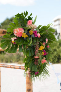 Outdoor Tropical Beach Wedding Bamboo Ceremony Arch with Pink and Yellow Florals with Greenery