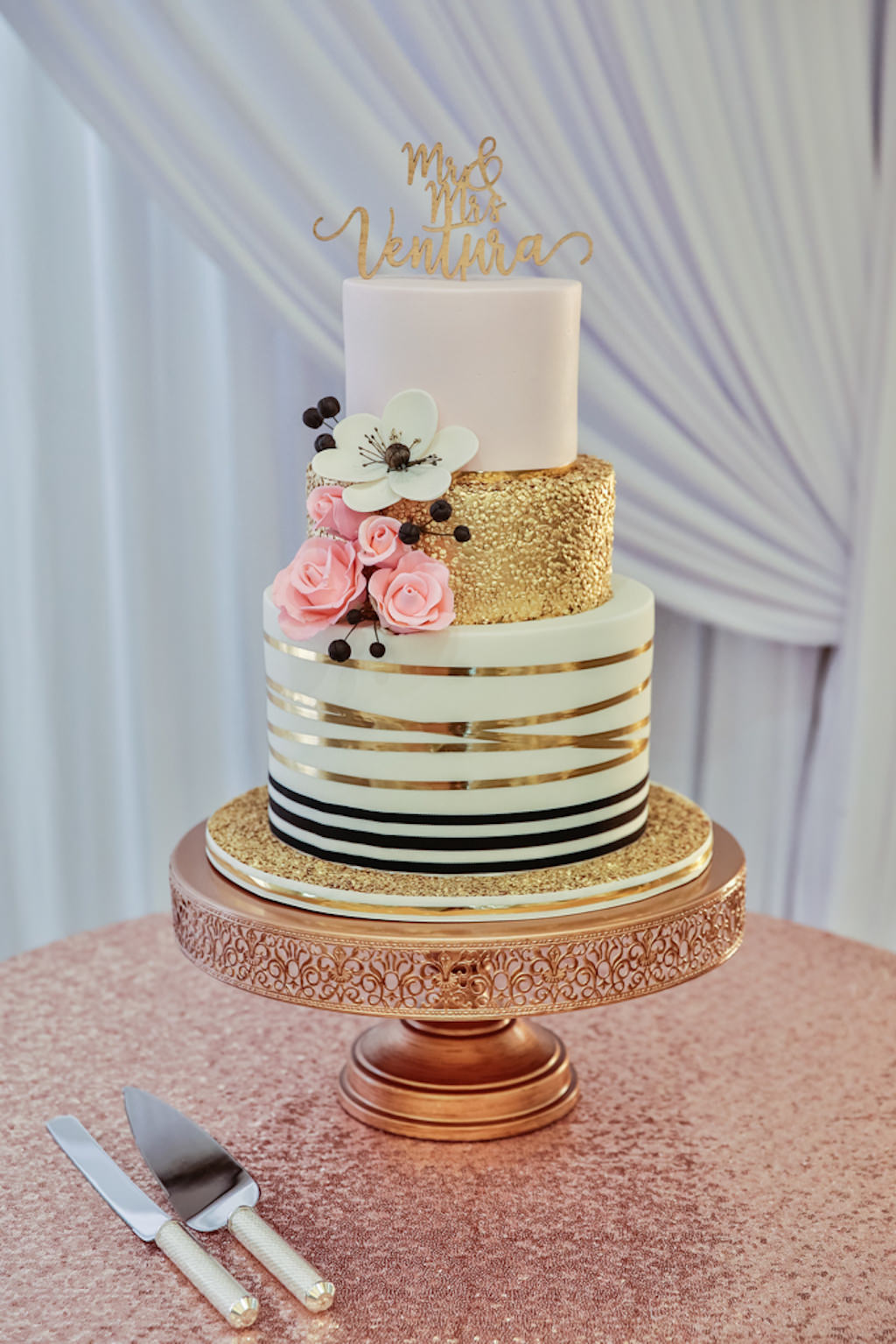Three Tier Round Wedding Cake with BLush Pink, Gold Foil, Gold Ribbon and Black and White Stripe Icing, Edible Black, White, and Pink Floral Decorations, Rose Gold Cake Stand and Sequin Linen, and Stylish Gold Caketopper
